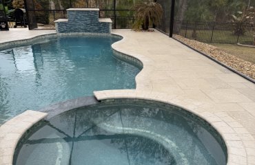 Clean Florida pool deck with light-colored pavers and pool screen enclosure