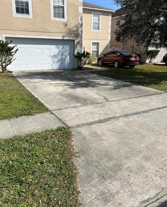 Concrete driveway and stucco home exterior before pressure washing in Central Florida