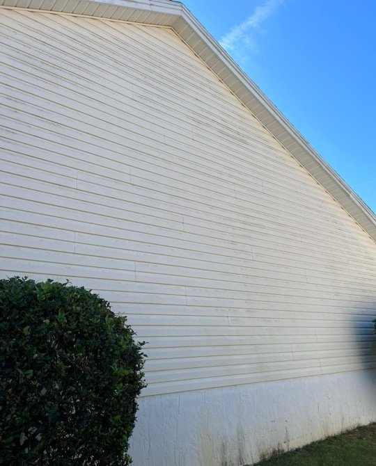 Clean white vinyl siding on large home exterior after soft washing in Central Florida