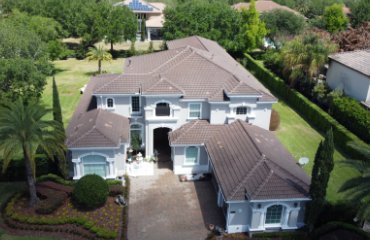 Aerial view of large luxury two-story Florida home with terracotta tile roof